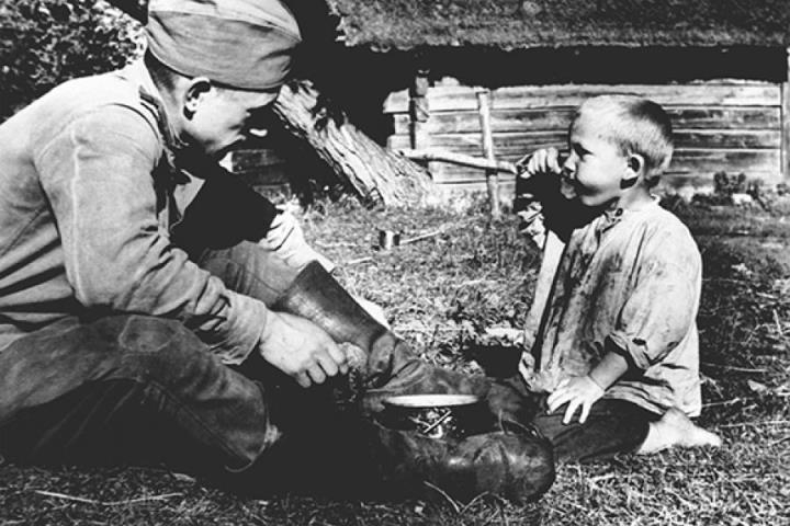 A soldier shares food with a boy